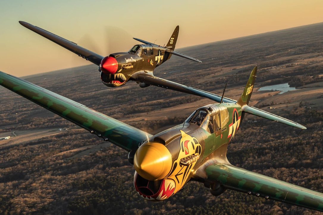 A pair of Curtiss P-40 warbirds in formation at sunset